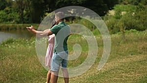 Beautiful couple dance in the field. the enjoy each other and smile. Summer weather. Romantic atmophere. slow motion