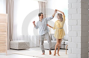 Beautiful  couple dancing in living at home