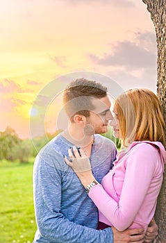 Beautiful couple embracing on date in sunset