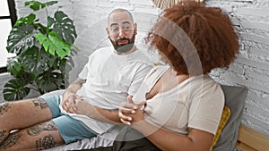 Beautiful couple enjoying morning conversation, sitting together on bed in cozy bedroom. expressing love and joy, they speak with