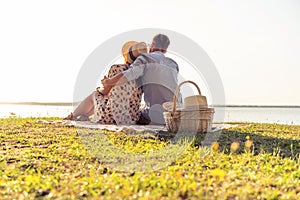 Beautiful couple enjoying picnic time on the sunset