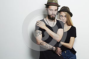 Beautiful couple in hat together. Hipster boy and girl. Bearded young man and blonde. Tattoo