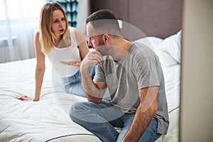 Beautiful couple having argument in bedroom at home