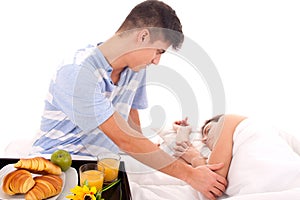 Beautiful couple having breakfast lying in the bed