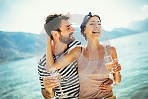 Couple having fun on the beach, drinking cocktails and smiling
