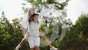 Beautiful Couple Having Fun In Nature. Portrait Of Handsome Man Carrying Woman.