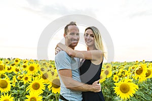 Beautiful couple having fun in sunflowers fields