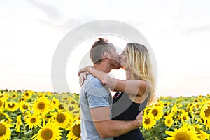 Beautiful couple having fun in sunflowers fields