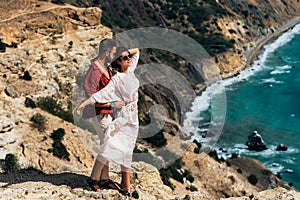 Beautiful couple hugging by the sea. Honeymoon trip. A man and a beautiful woman by the sea. A couple in love is traveling.