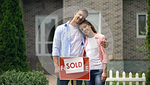 Beautiful couple hugging and smiling on background of luxury house, investment