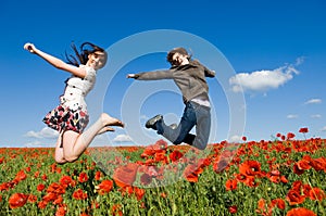 Beautiful couple jumping in the poppy field