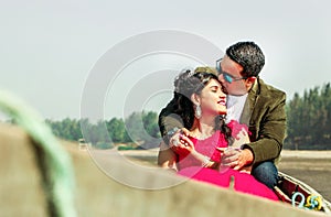 Beautiful couple kissing while sitting on rowboat at beach