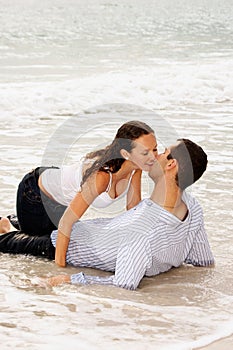 Beautiful couple kissing in the tide