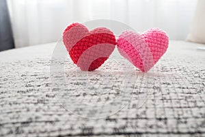 Beautiful couple knitted fabric heart shape on fabric sofa. photo