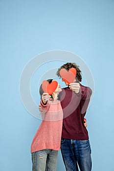 Beautiful couple in love on blue studio background. Valentine's Day, love and emotions concept