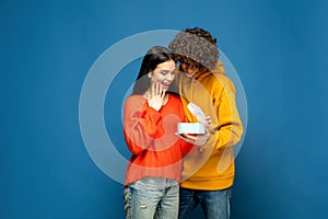 Beautiful couple in love on blue studio background. Valentine& x27;s Day, love and emotions concept