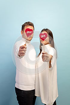 Beautiful couple in love on blue studio background. Valentine& x27;s Day, love and emotions concept