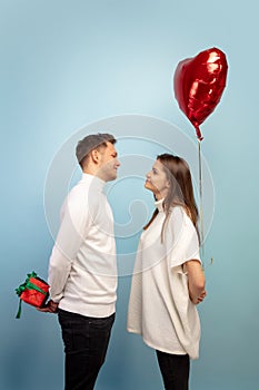 Beautiful couple in love on blue studio background. Valentine's Day, love and emotions concept
