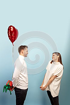 Beautiful couple in love on blue studio background. Valentine's Day, love and emotions concept