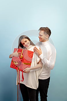 Beautiful couple in love on blue studio background. Valentine& x27;s Day, love and emotions concept