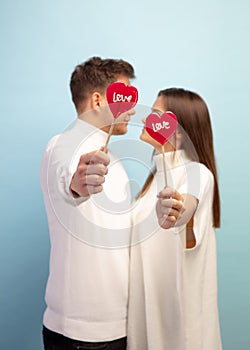 Beautiful couple in love on blue studio background. Valentine& x27;s Day, love and emotions concept