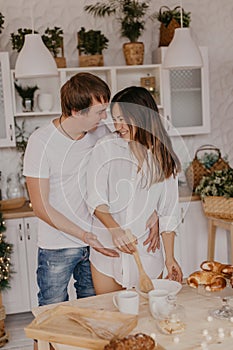 Beautiful couple in love celebreting Christmas. Kitchen breakfast - Image
