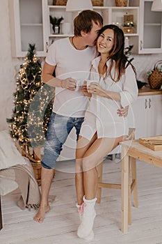 Beautiful couple in love celebreting Christmas. Kitchen breakfast - Image