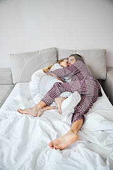 Beautiful couple in love cuddling and sleeping in bed