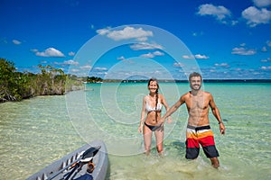 Beautiful couple in love kayaking at tranquil Bacalar lake. Riviera Maya, Mexico. Tropical travel.