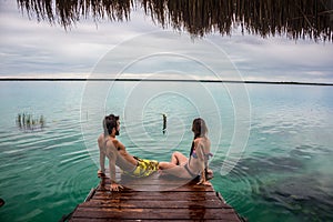 Beautiful couple in love looking at tranquil Bacalar lake
