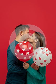 Beautiful couple in love on red studio background. Valentine's Day, love and emotions concept