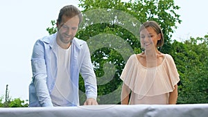 Beautiful couple in love setting table, preparation for family dinner traditions