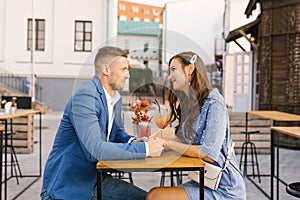 Beautiful couple in love is sitting at a table in an outdoor cafe on a date