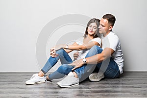 Beautiful couple in love on white background dressed in blue jeans and white undershirt