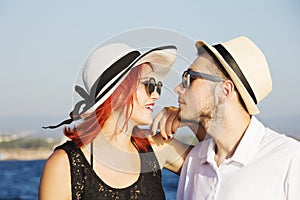 Beautiful couple of lovers sailing on a boat. Two fashion models posing on a sailing boat at sunset