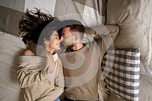 Beautiful couple lying on bed relaxing together