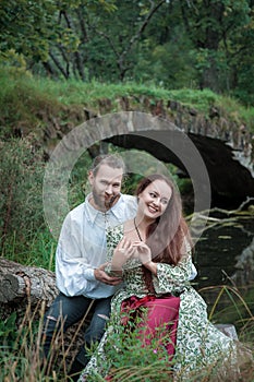 Beautiful couple man and woman in medieval costume style sitting on the tree