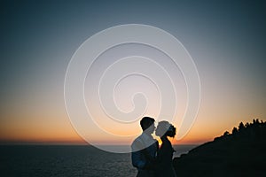 Beautiful couple man and woman on the sunset on the sea