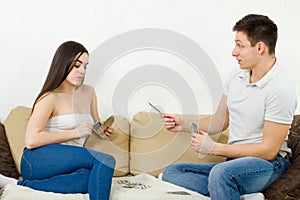 Beautiful couple playing cards indoor.