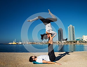 Beautiful couple practicing acro yoga in the morning