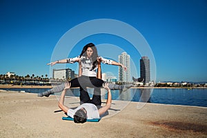 Beautiful couple practicing acro yoga in the morning