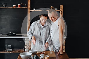 Beautiful couple preparing a meal together while spending free time at home.