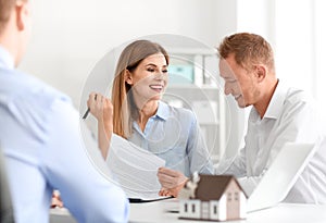 Beautiful couple with real estate agent in office