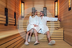 Beautiful couple relaxing in infrared sauna during wellness weekend