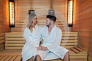 Beautiful couple relaxing in infrared sauna during wellness weekend