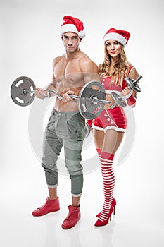 Beautiful couple in santa claus clothes doing workout