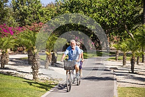 Beautiful couple of senior and mature married, riding a doble bike, tandem, together to have fun with a great and sunny day -