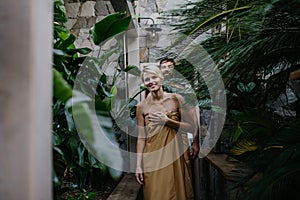 Beautiful couple standing in hotel greenhouse,enjoying romantic wellness weekend in spa. Concept of Valentine& x27;s Day.