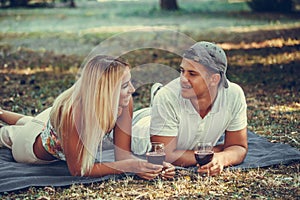 Beautiful  couple talking, flirting and enjoying a glass of wine on a romantic picnic
