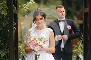 Beautiful couple on their wedding day. Portrait of groom and bride. Green background